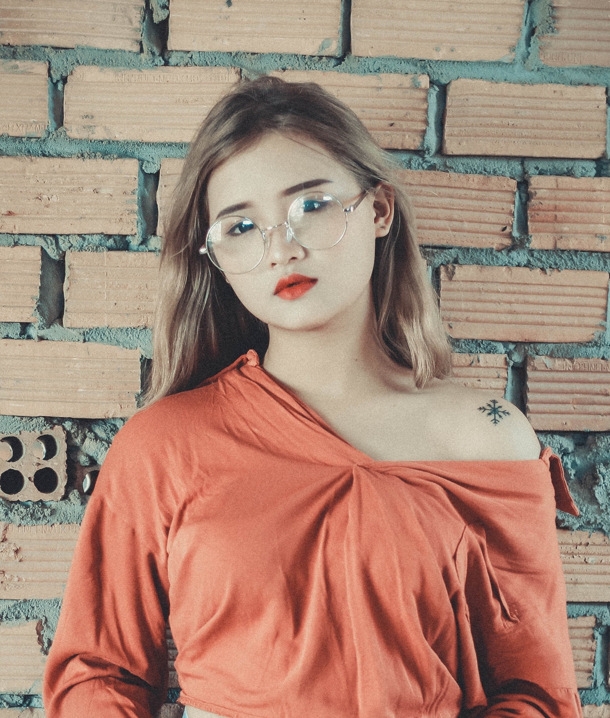 Asian woman with dark blonde hair wearing eyeglasses