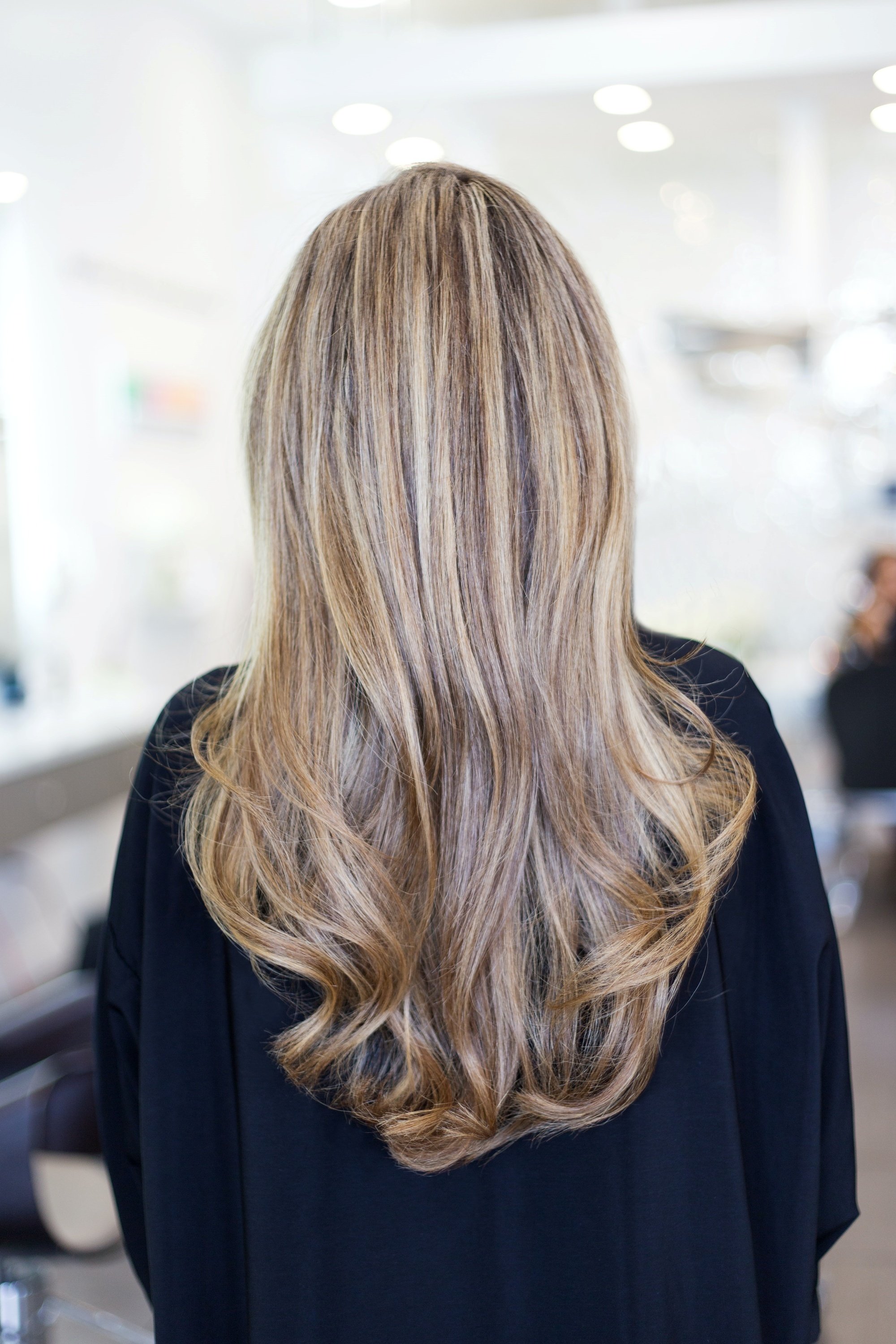 Back shot of a woman with long balayage hair