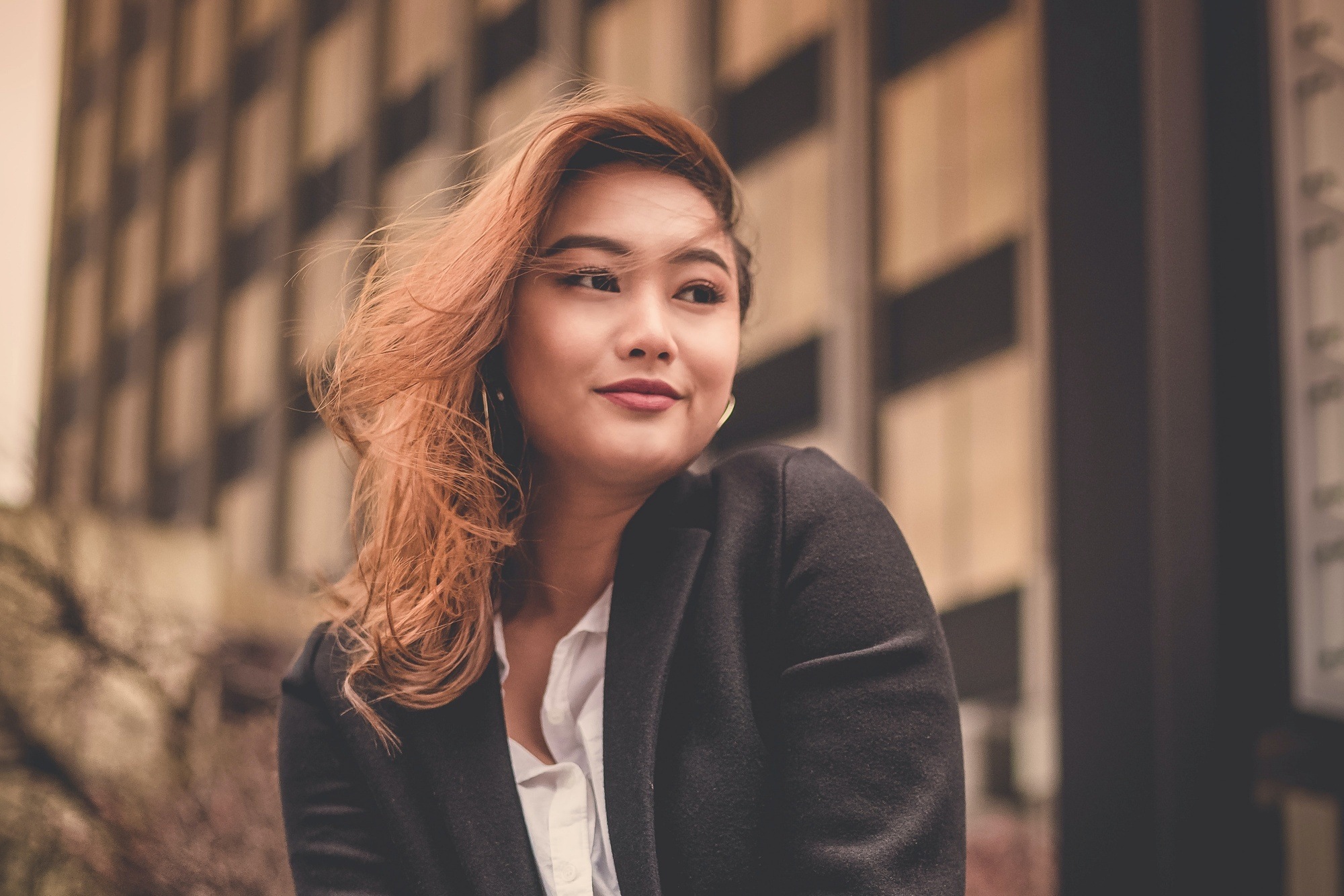 Woman with deep strawberry blonde hair wearing a black jacket