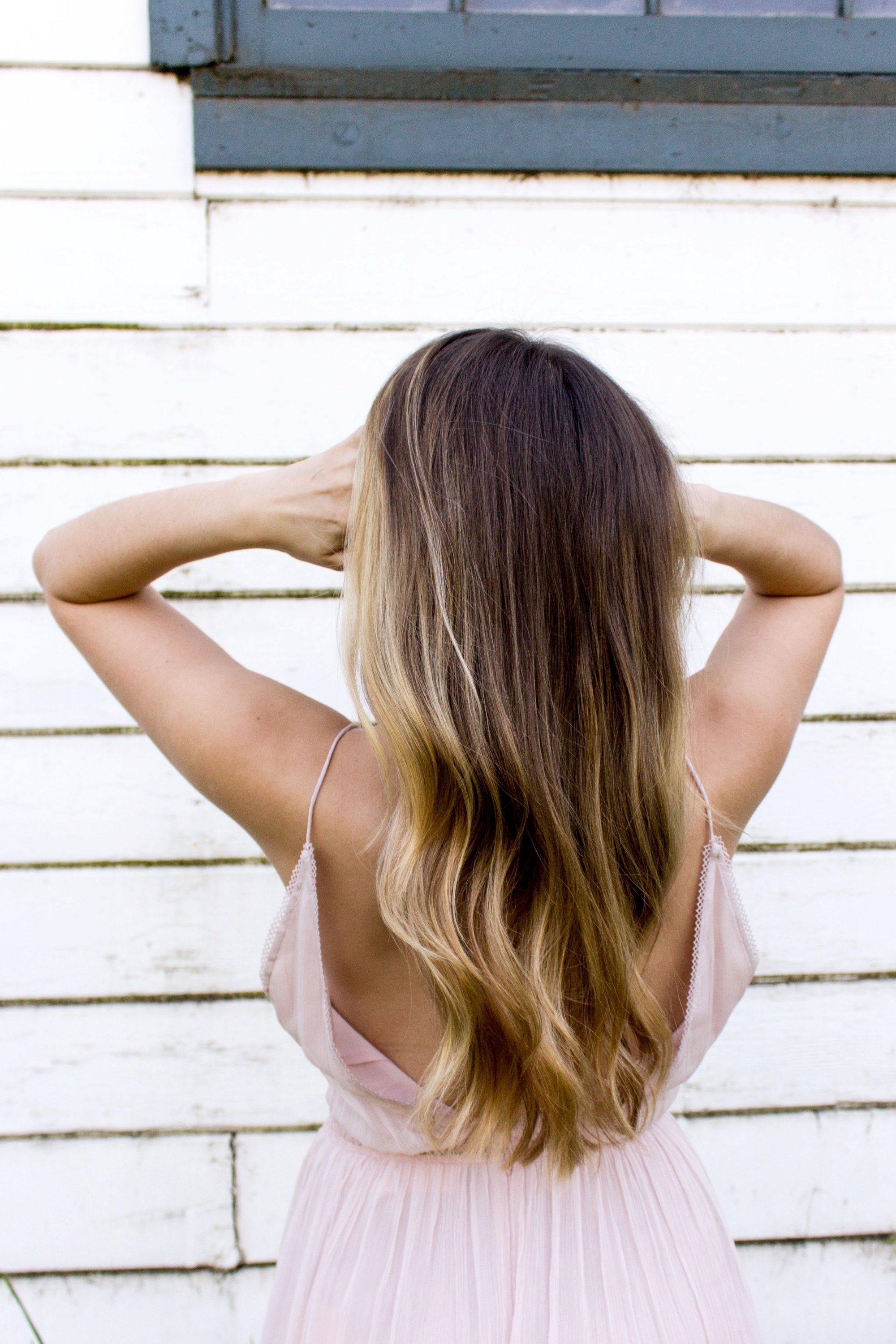 Back shot of a woman with long hair with blonde highlights