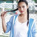 Asian woman with a round face with hair in boxer braid wearing a sporty attire outdoors