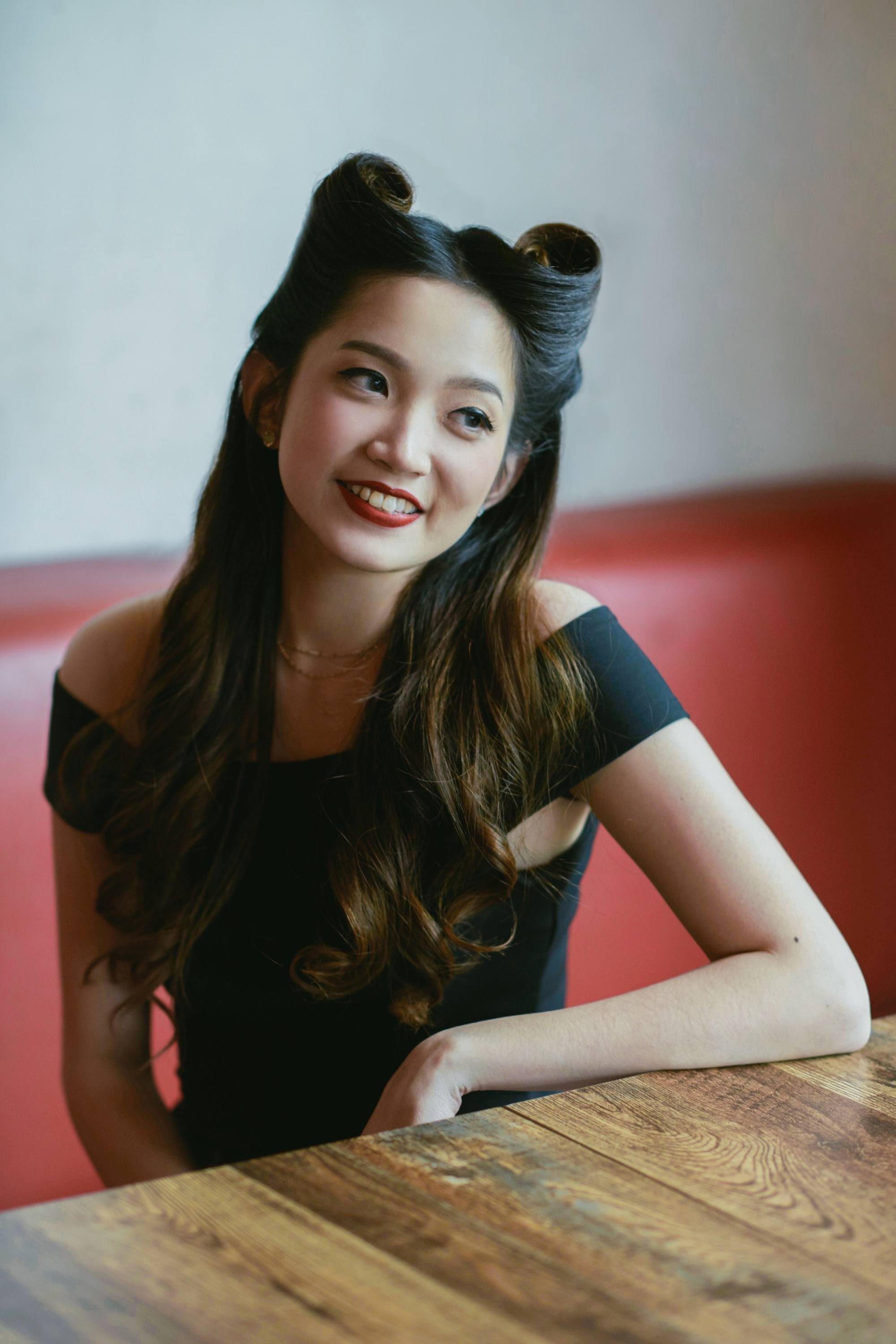 Asian woman with long rockabilly hair in victory rolls