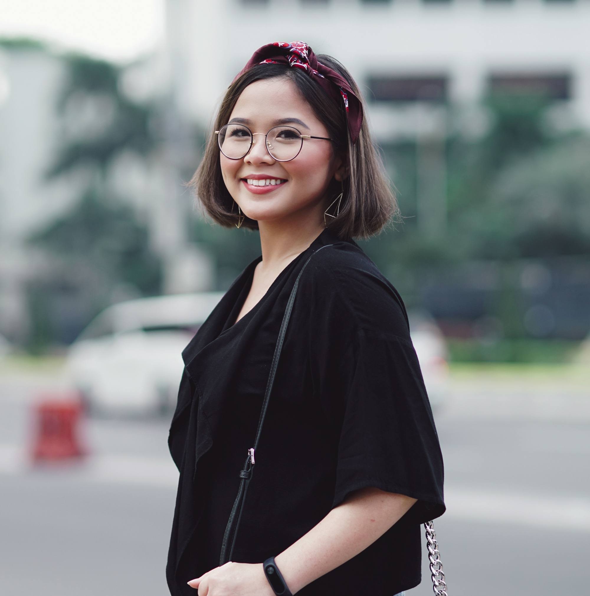 Coiffures jusqu'au menton : femme asiatique aux cheveux noirs courts avec bandeau portant des lunettes et une chemise noire