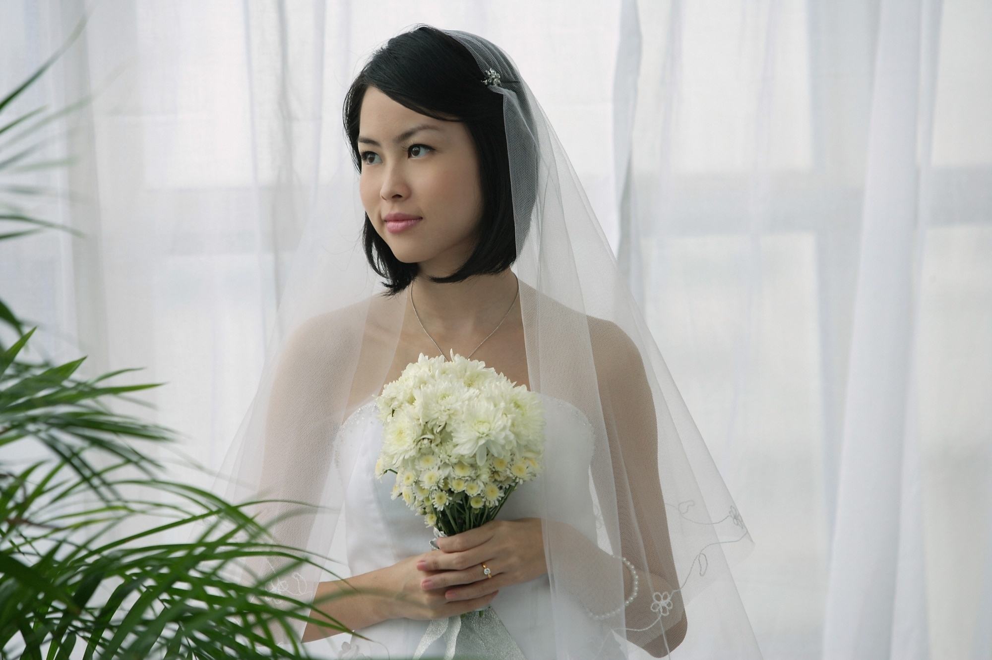 Asian woman with short hair wearing a wedding dress