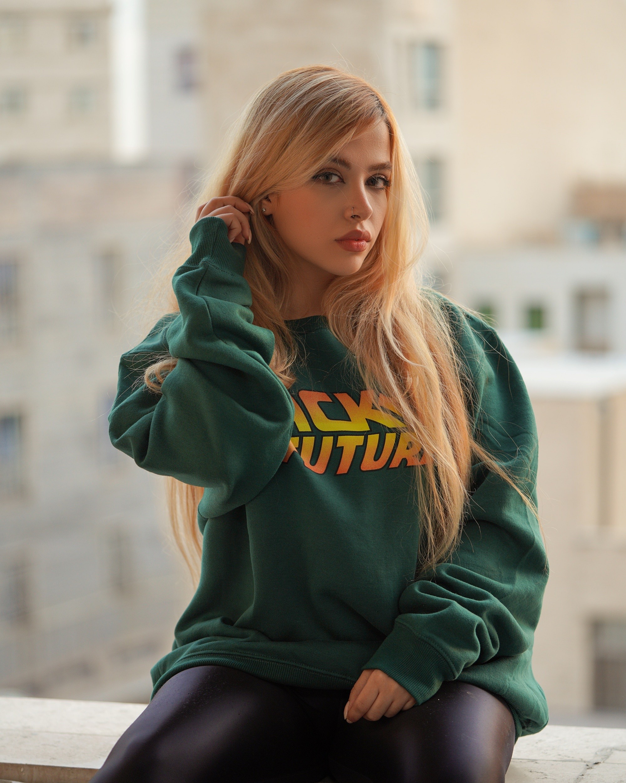 Woman with long blonde hair wearing a green sweater