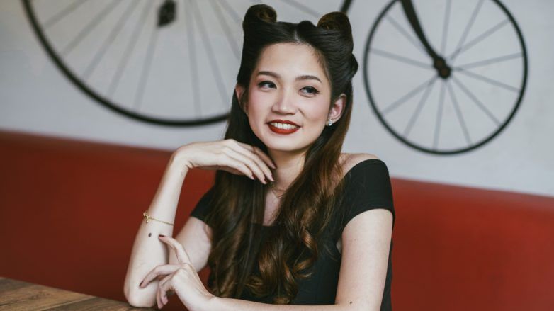 Victory rolls: Asian woman in a cafe with long dark hair in victory rolls