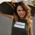 Hairstyles for skaters: Woman with brown wavy hair holding a skateboard