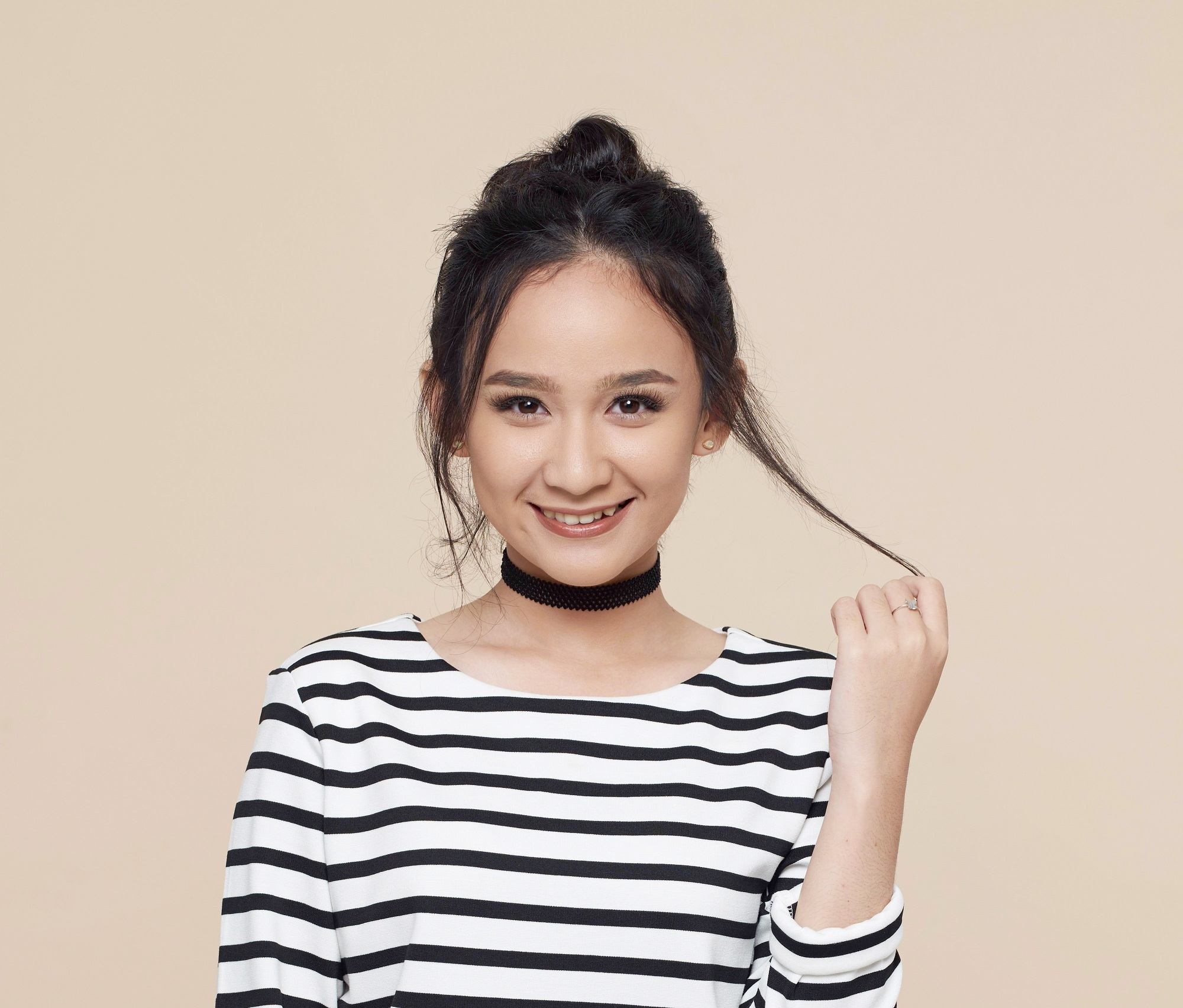 Asian girl with messy bun againsy oyster background to represent users of the new Sunsilk Shampoos