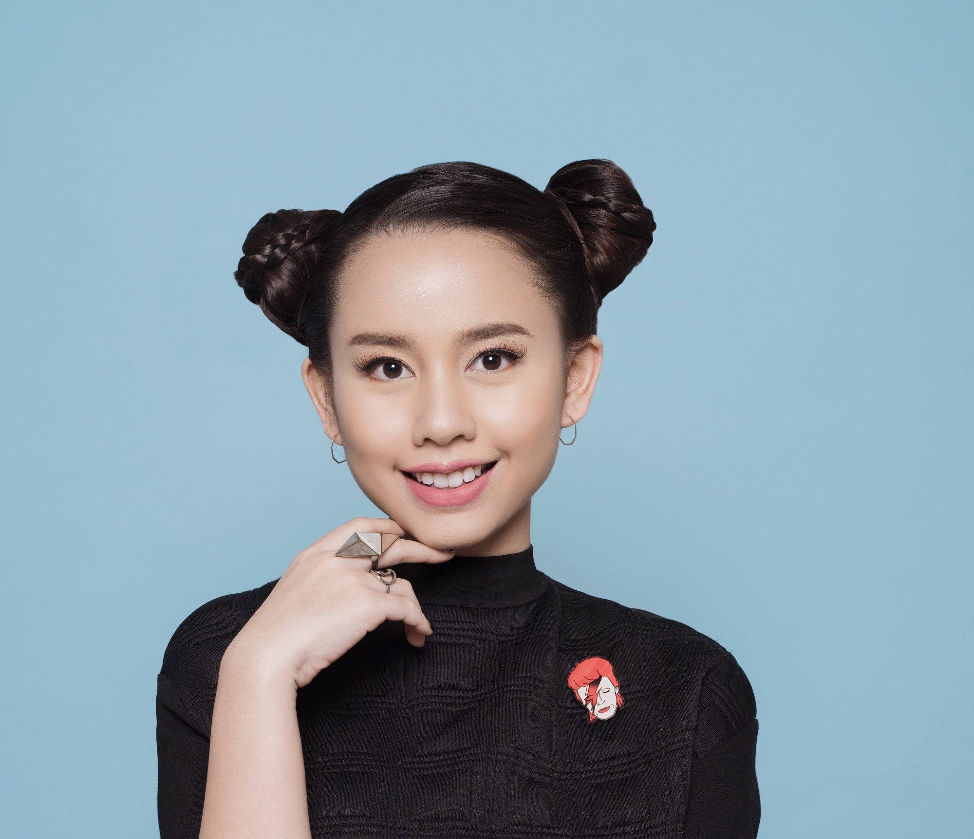 Asian girl with hair in two side buns against blue background to represent users of new Sunsilk Smooth and Manageable Shampoo