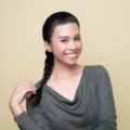 Advent calendar: Closeup shot of an Asian woman with long hair in French braid wearing a gray long-sleeved top