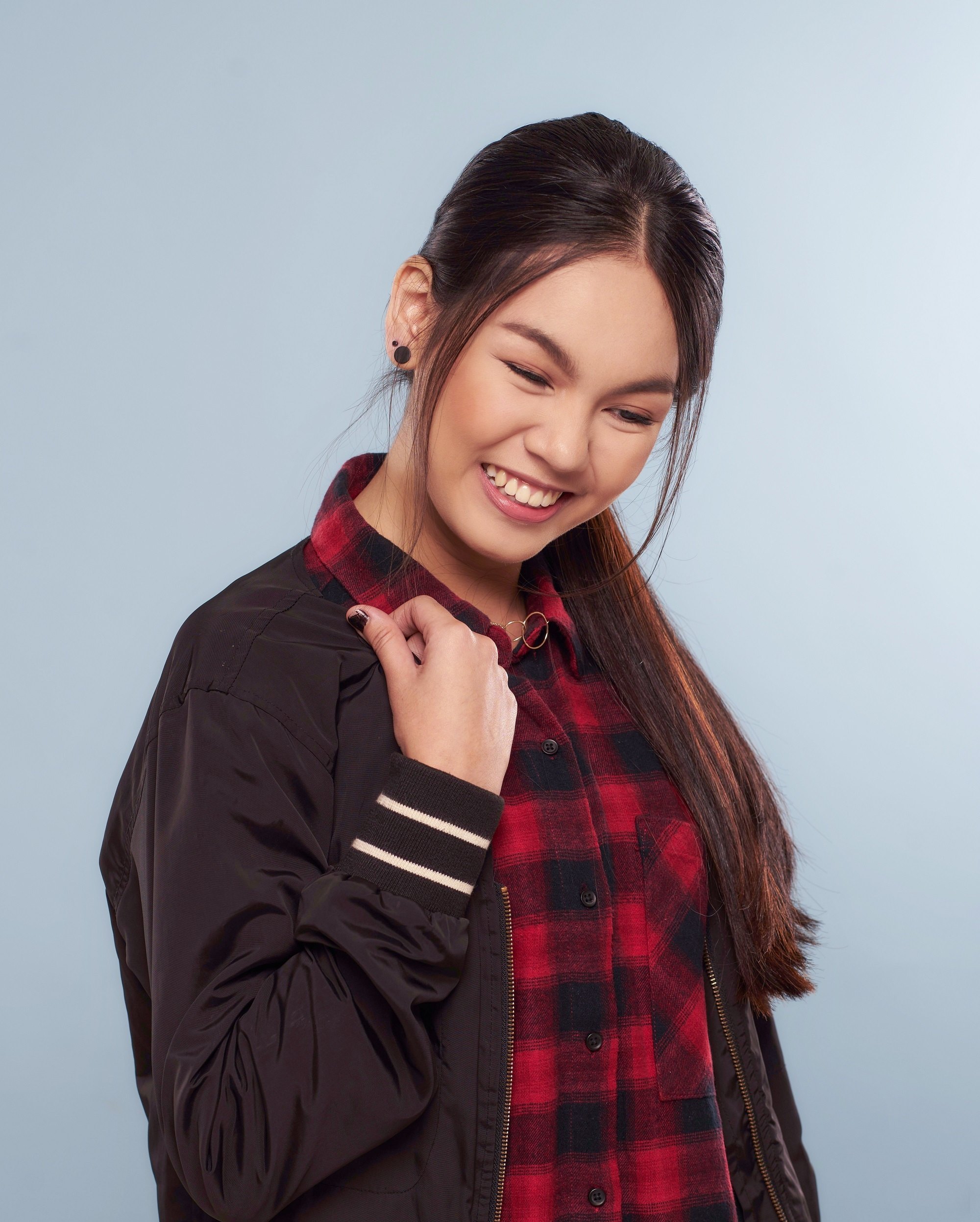 Advent calendar: Asian woman with long black hair in a ponytail wearing a red plain blouse and black jacket