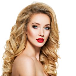 Honey blonde: Closeup shot of a woman with long blonde wavy hair and red lips against a white background