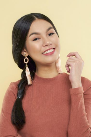 Messy side braid: Asian woman wearing a brown long-sleeved shirt with long black hair in braids
