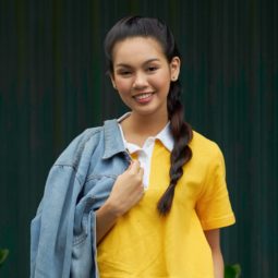 RopeMessy side braid: Asian woman with long black hair in a rope braid wearing a yellow shirt outdoors