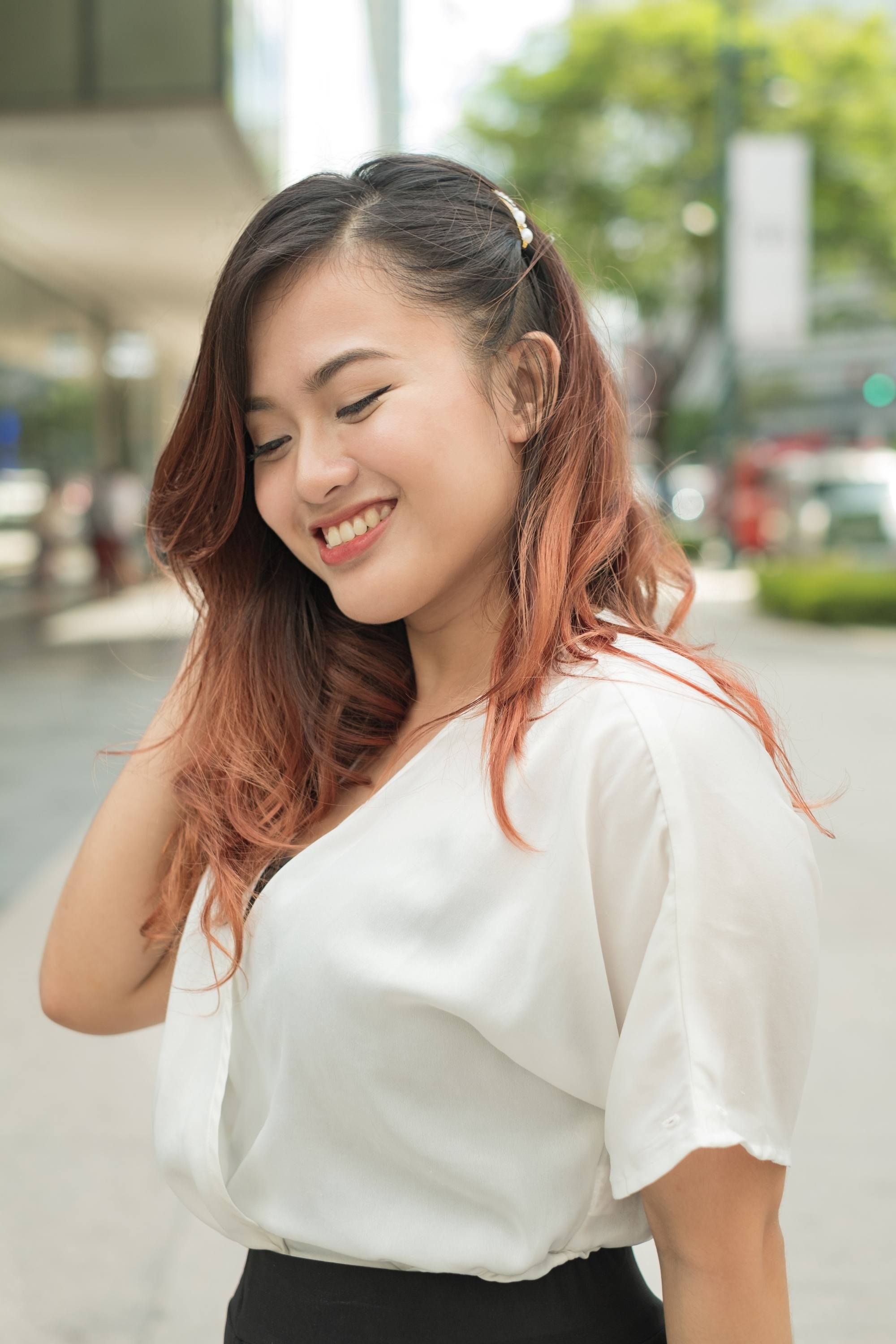 Christmas hairstyles: Filipina woman with long brown hair with clip wearing a white blouse outdoors
