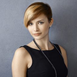 Elegant hairstyles for short hair: Woman with a blonde pixie cut wearing a black sleeveless top