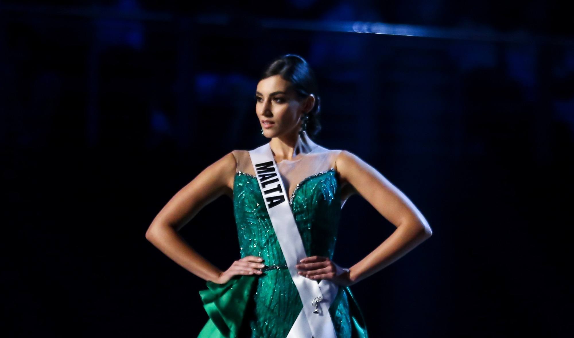 Miss Universe 2018 hairstyles: Miss Malta Francesca Mifsud with black hair in chignon wearing a green evening gown on stage