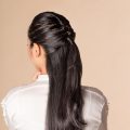 Back shot of an Asian woman with long hair in a half updo