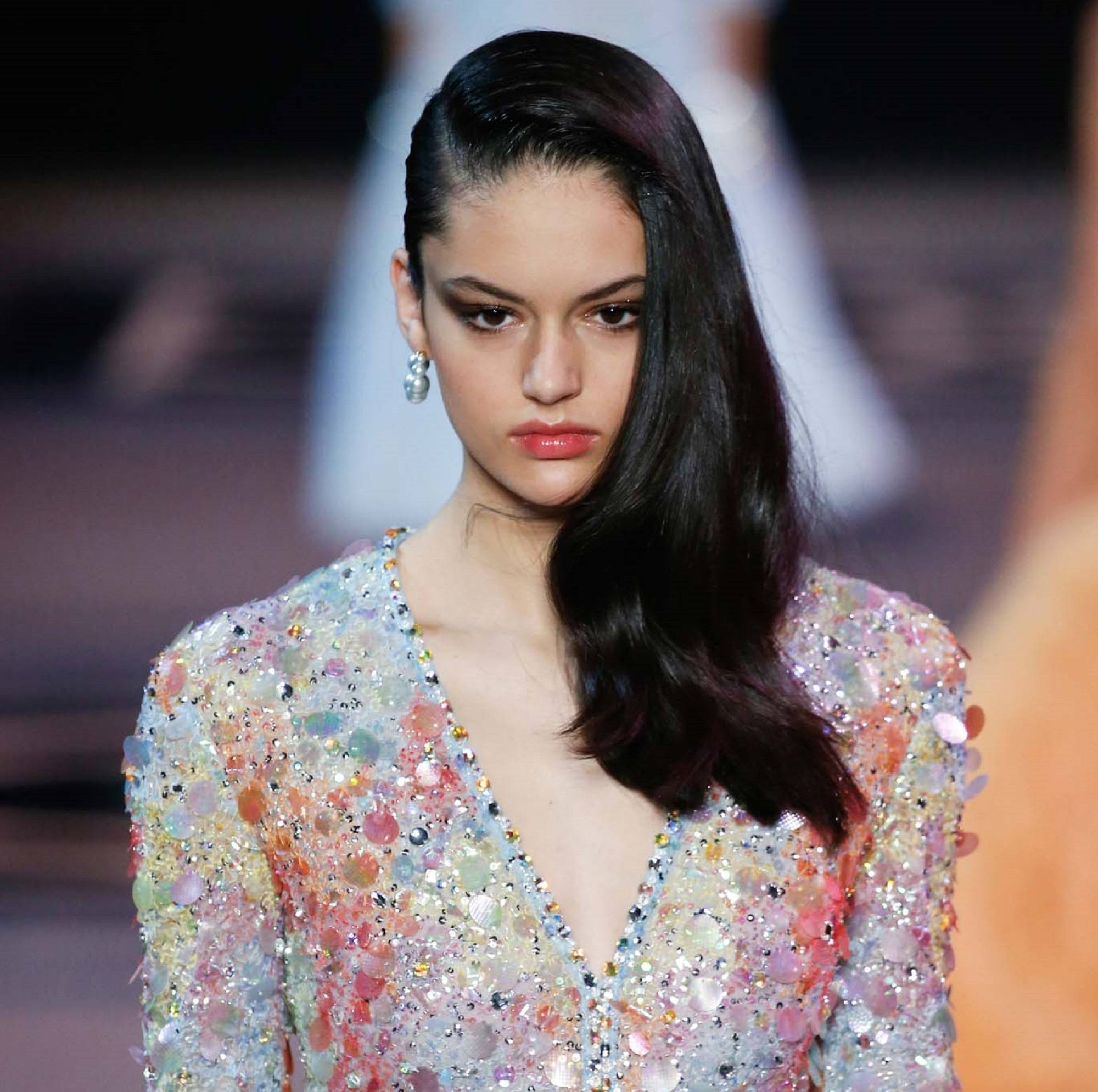 Paris Fashion Week 2019: Closeup shot of a woman with long black hair wearing a dress on the runway