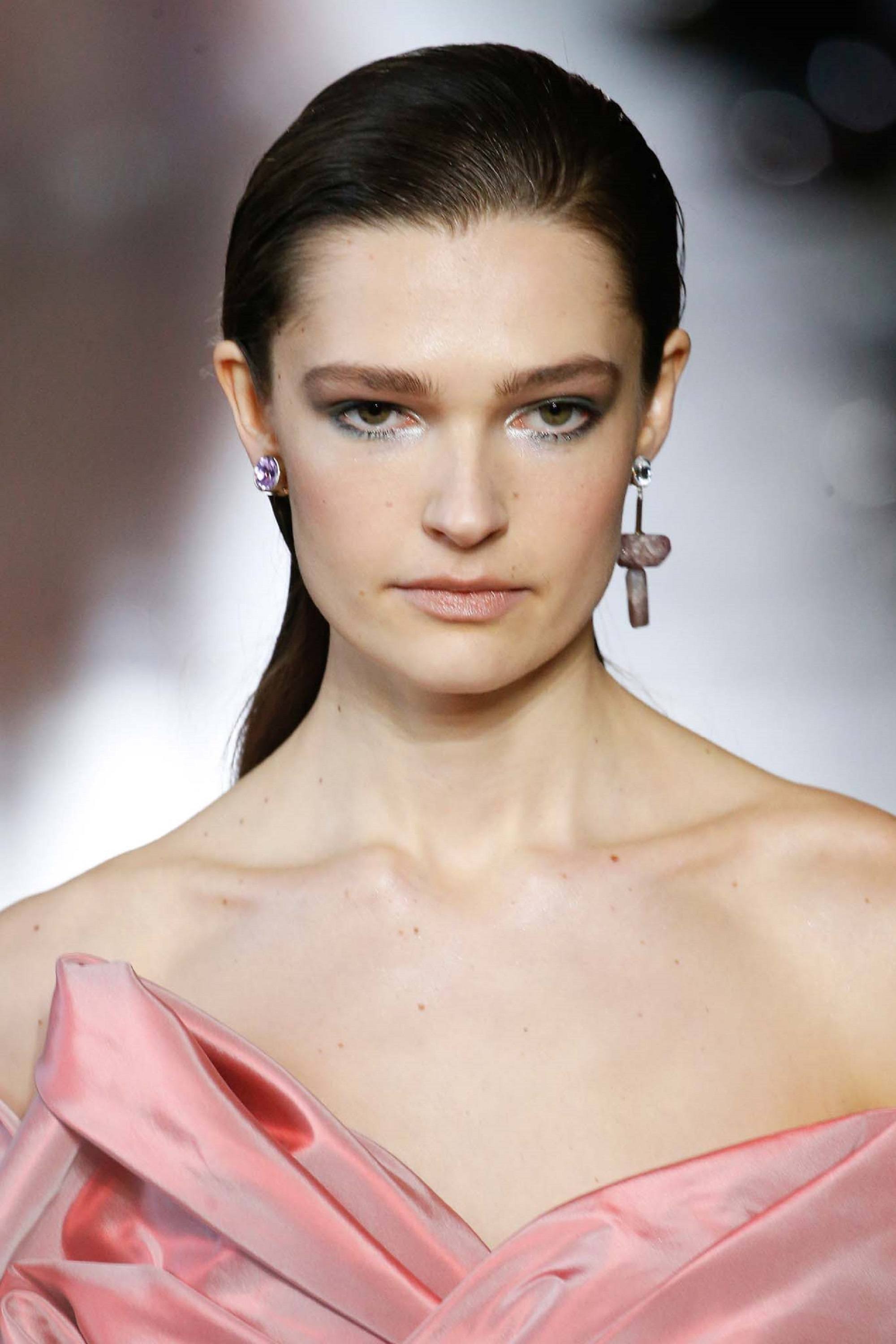 Paris Fashion Week 2019: Closeup shot of a woman with fair skin and long slicked back black hair