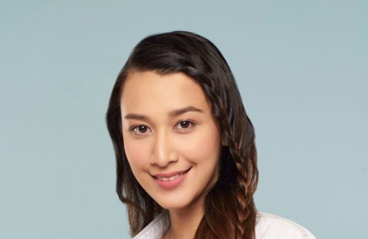 Simple braids: Asian woman wearing a white polo with long dark hair in face framing lace braid