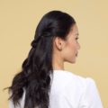 Valentine hairstyles: Back shot of an Asian woman with long black hair in half updo wearing a white blouse