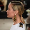 New York Fashion Week Hair: Side view shot of a woman with straight blonde hair in a ponytail wearing big earrings and white top