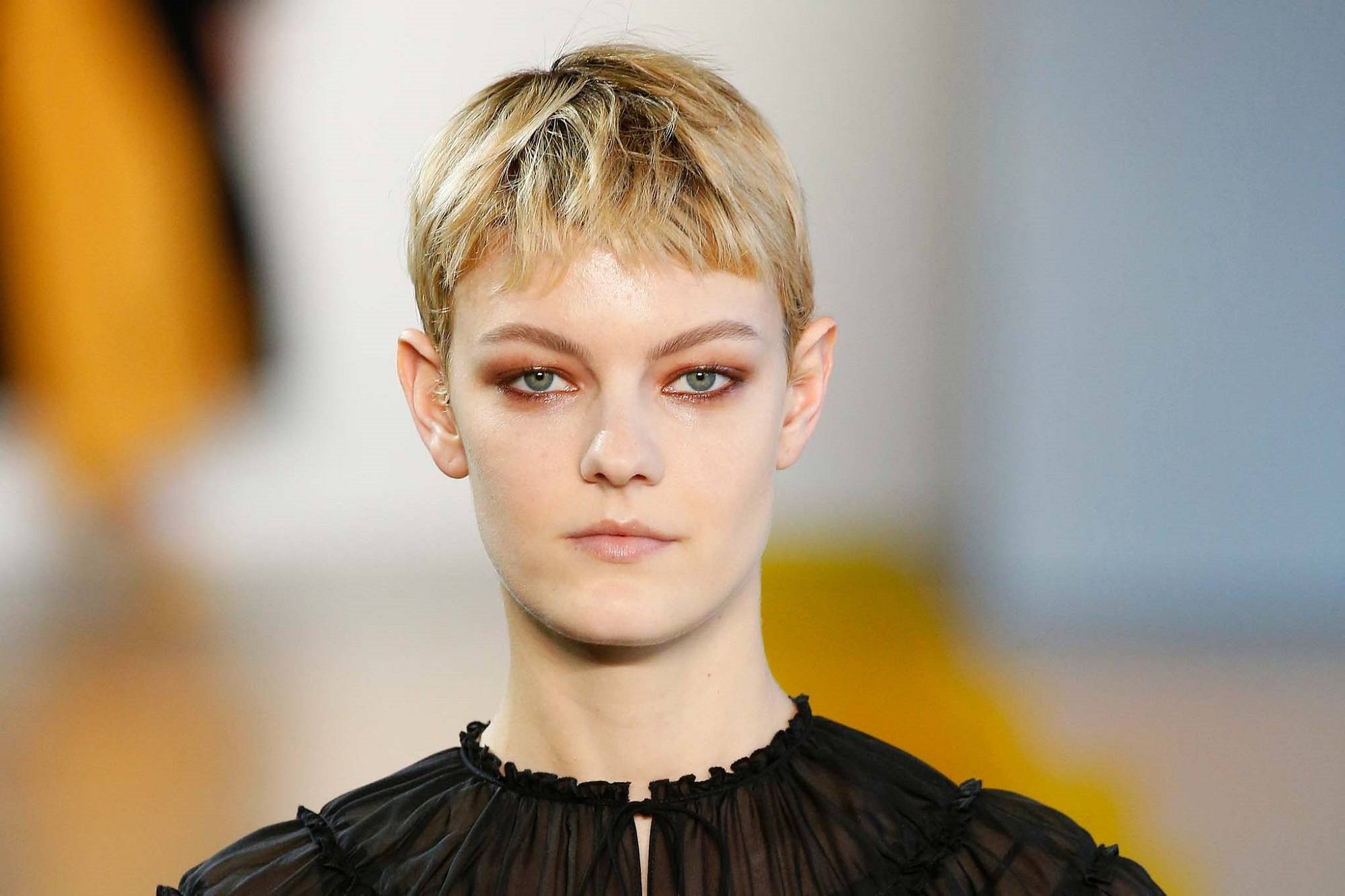 New York Fashion Week hair: Closeup shot of a woman with short blonde pixie cut wearing a black hair