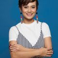 Short hair for round face: Asian girl with wearing short hair for chubby face has dangling earrings with her arms crossed in front