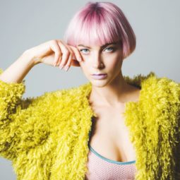 Pink ombre hair: Woman with short pink blunt bob with bangs wearing a yellow coat
