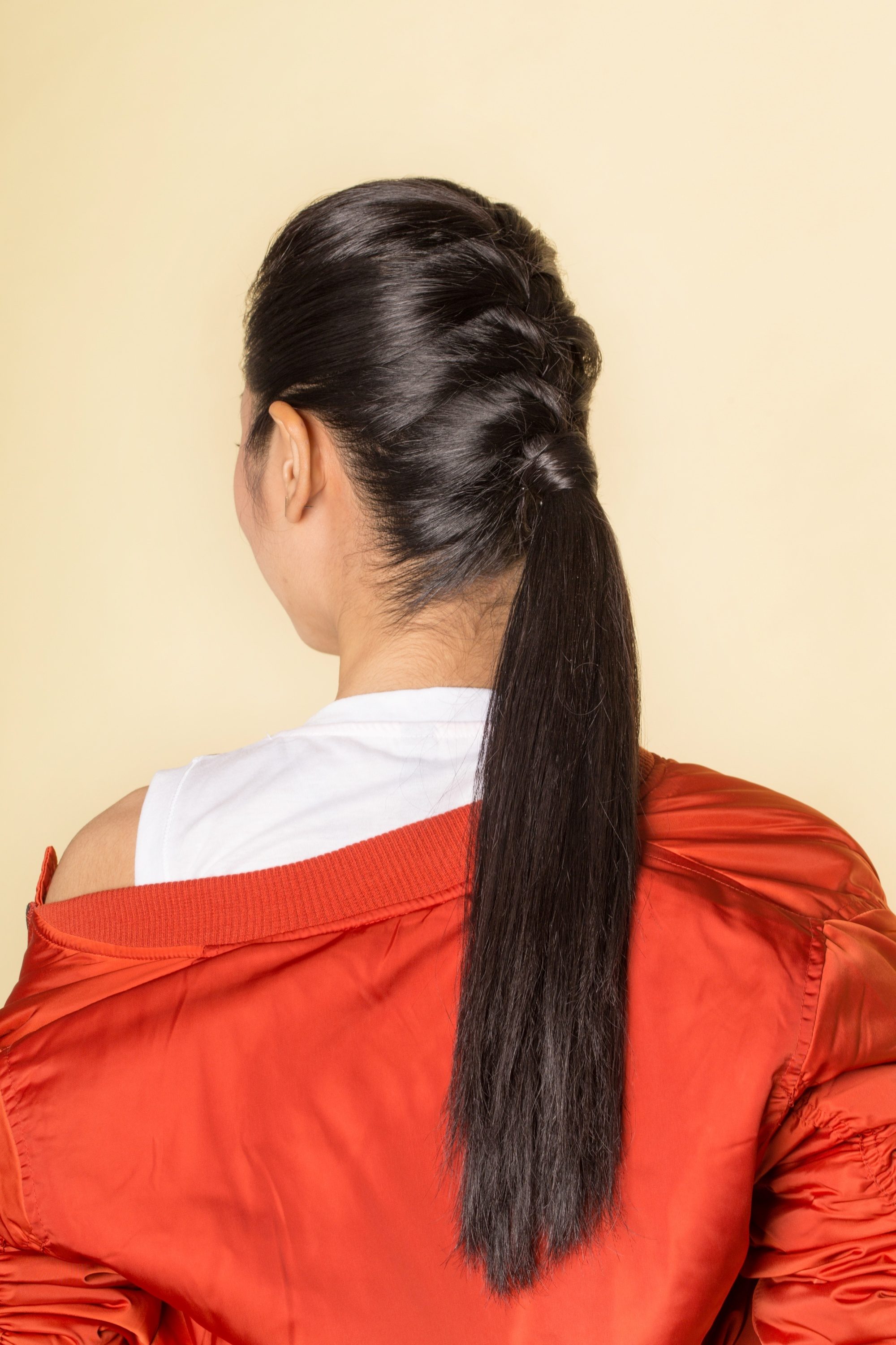 Back shot of an Asian woman with long black hair in a French braid and ponytail hairstyle