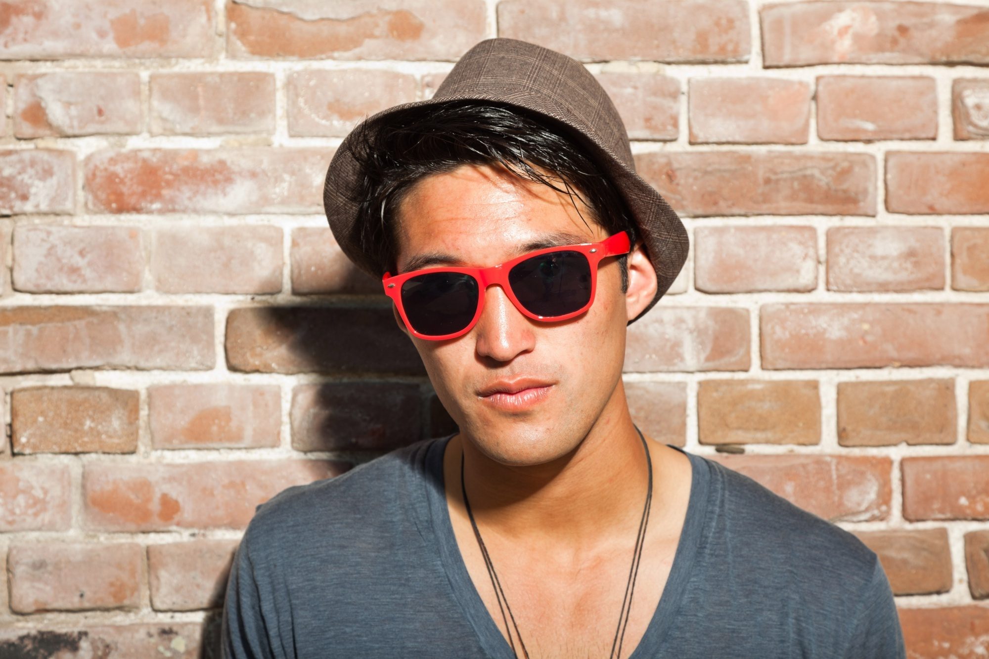 Hair care tips for men: Man wearing a hat and shades