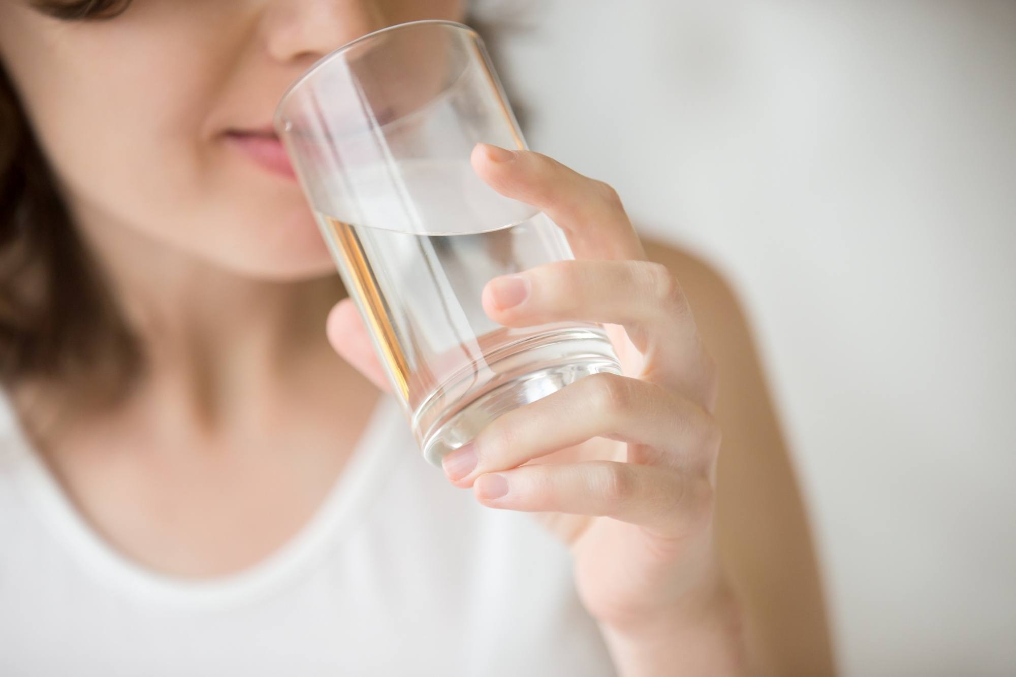 How to protect hair from pollution: Closeup shot of a woman drinking water from a glass