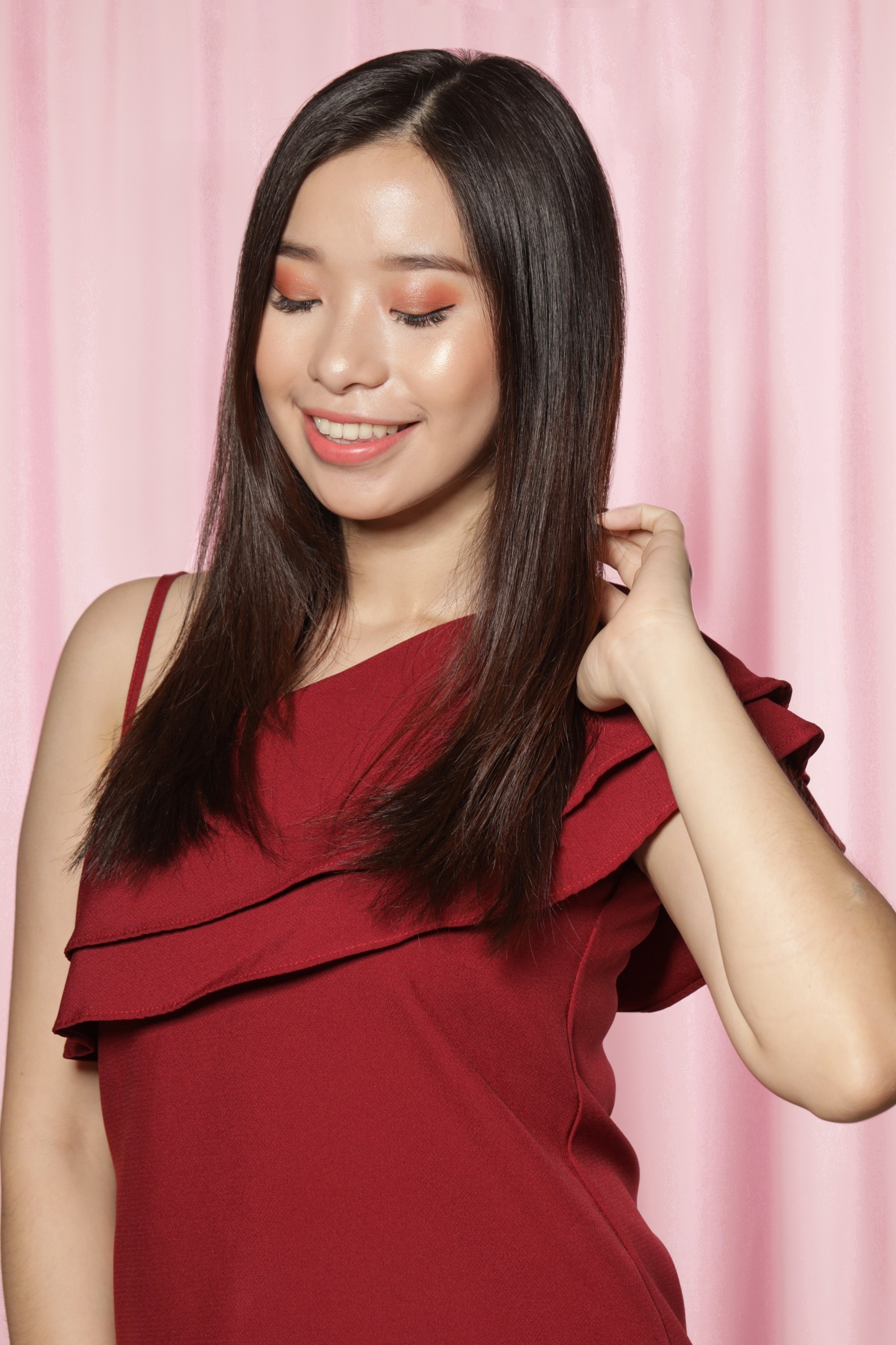 Asian woman with dark straight hair wearing a red top