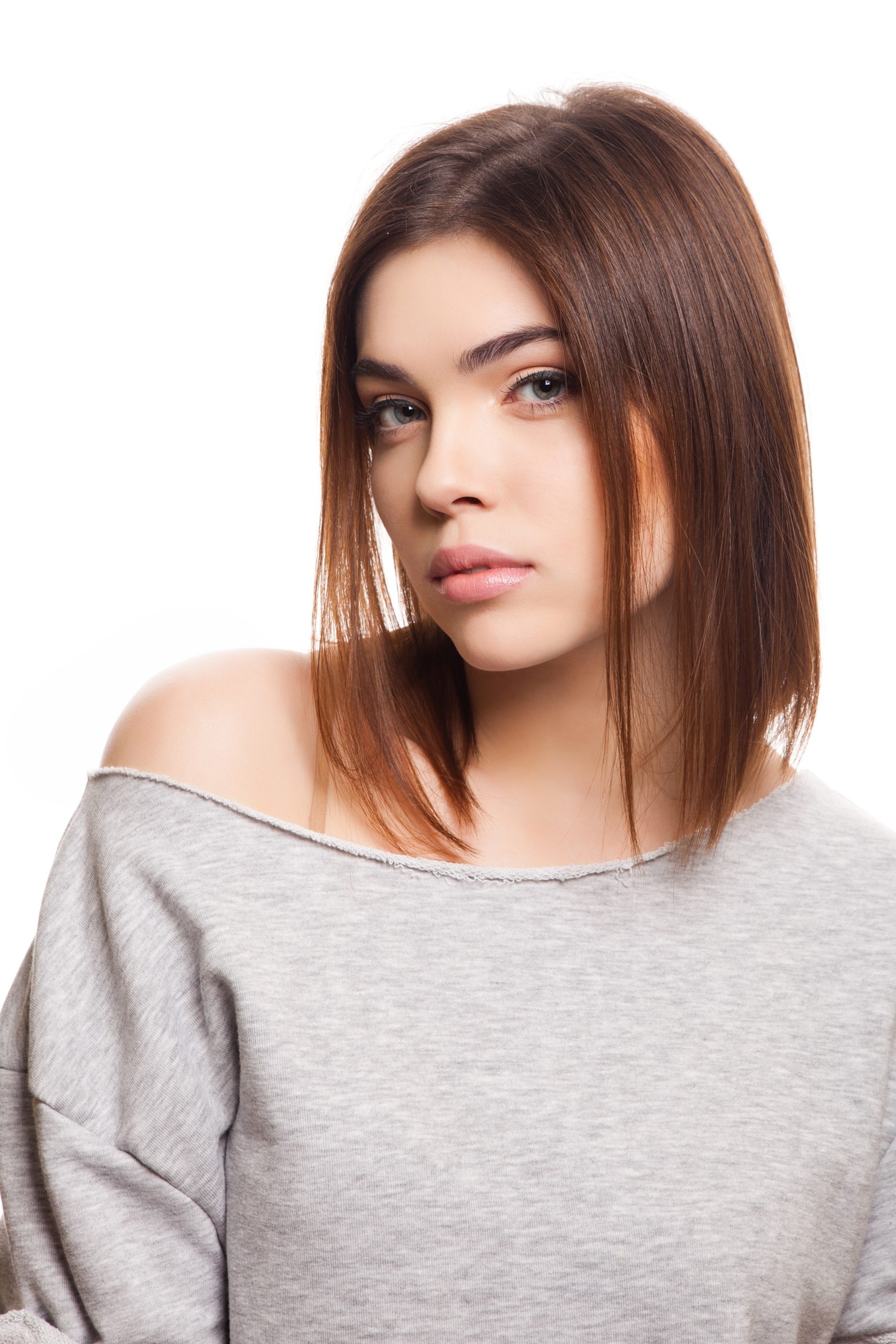 Long layered bob: Caucasian woman with brown hair wearing a gray shirt