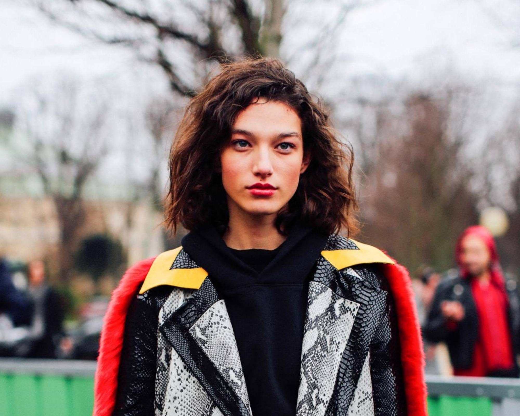 Mahogany Hair Color: Woman with short curly dark hair wearing a jacket outdoors