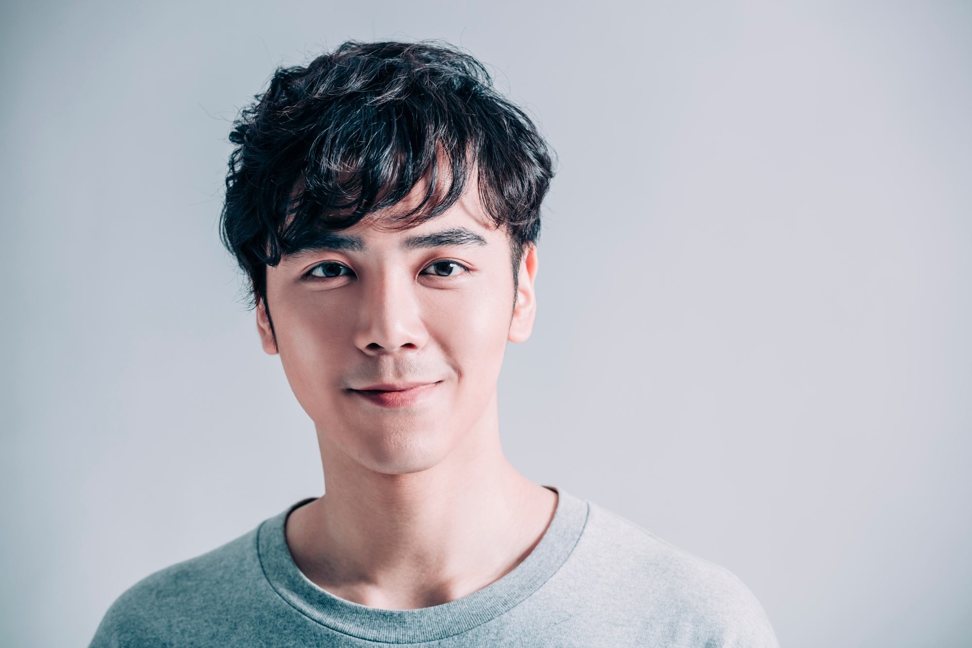 Asian man with short hair wearing a gray shirt