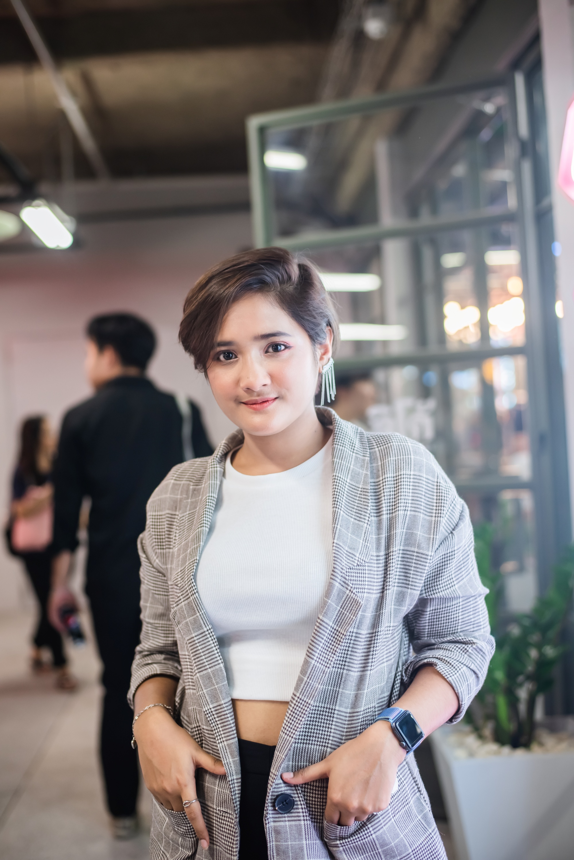 Asian woman with a long pixie cut wearing a gray cardigan