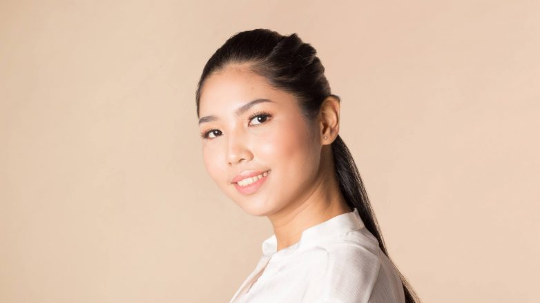 Asian woman with a half up Dutch Infinity Braid hairstyle wearing a white blouse