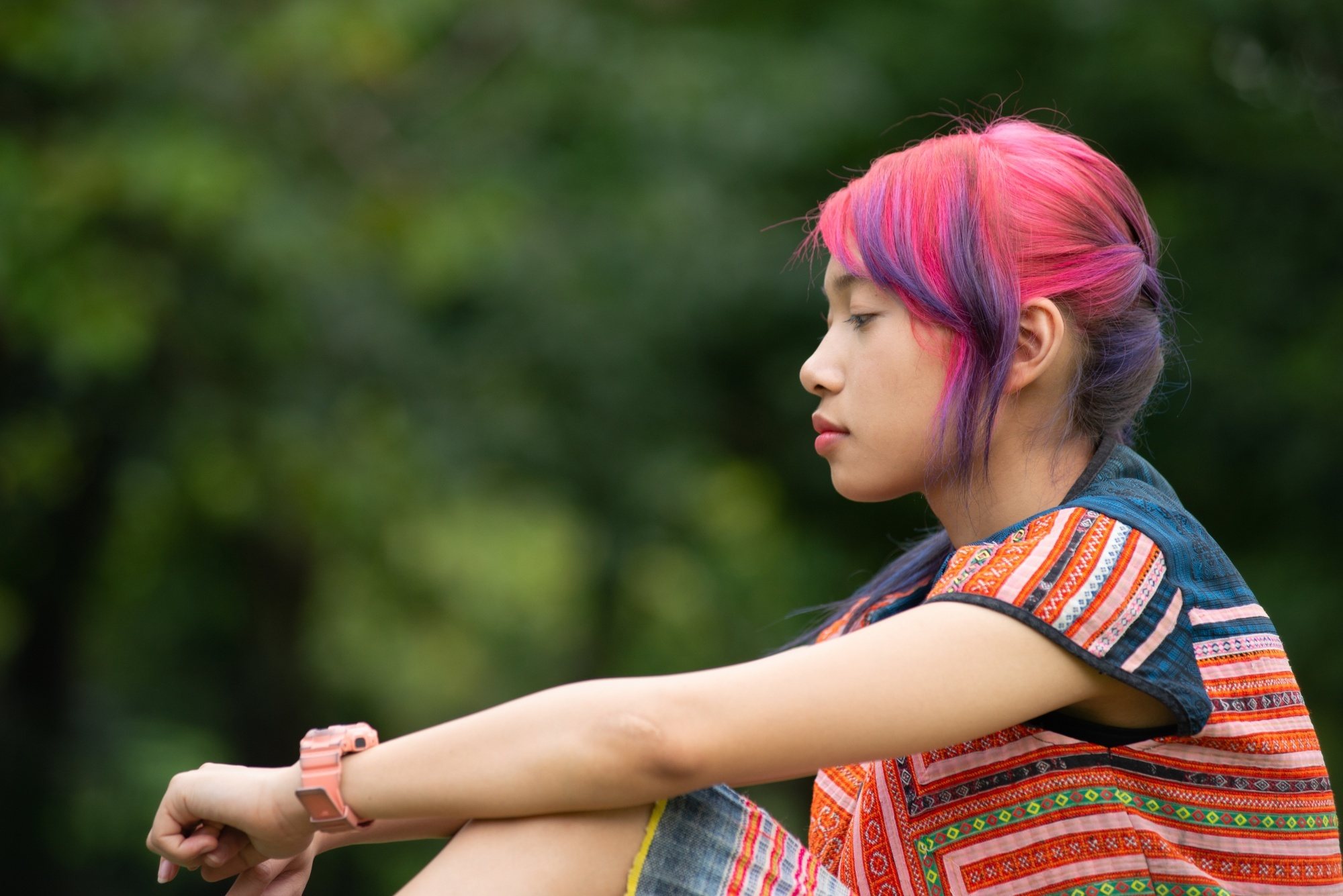 Side view of an Asian woman with colored hair