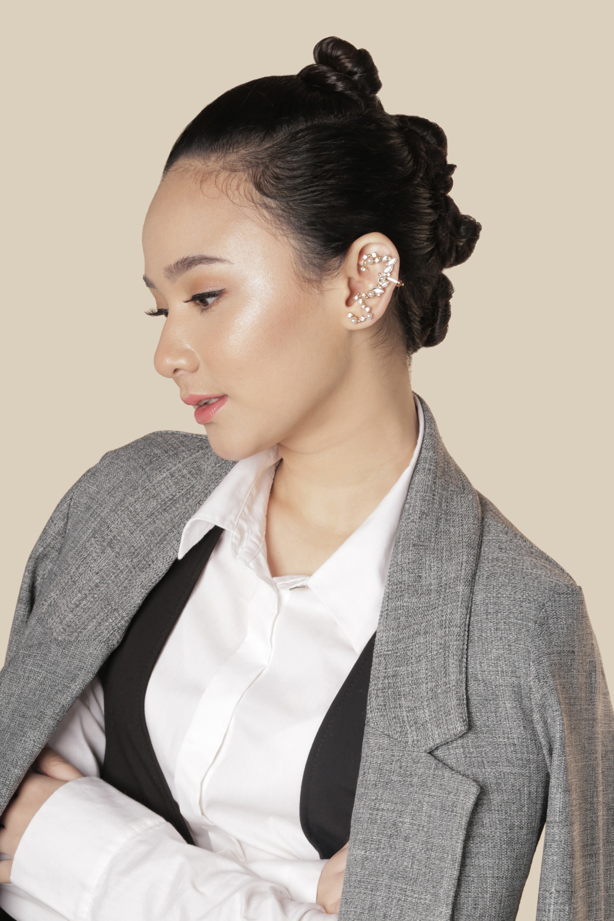 graduation hairstyles: girl wearing a grey coat is looking sideways to reveal her hairstyle