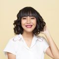 Layered curly hair: Asian woman with short black curly hair smiling