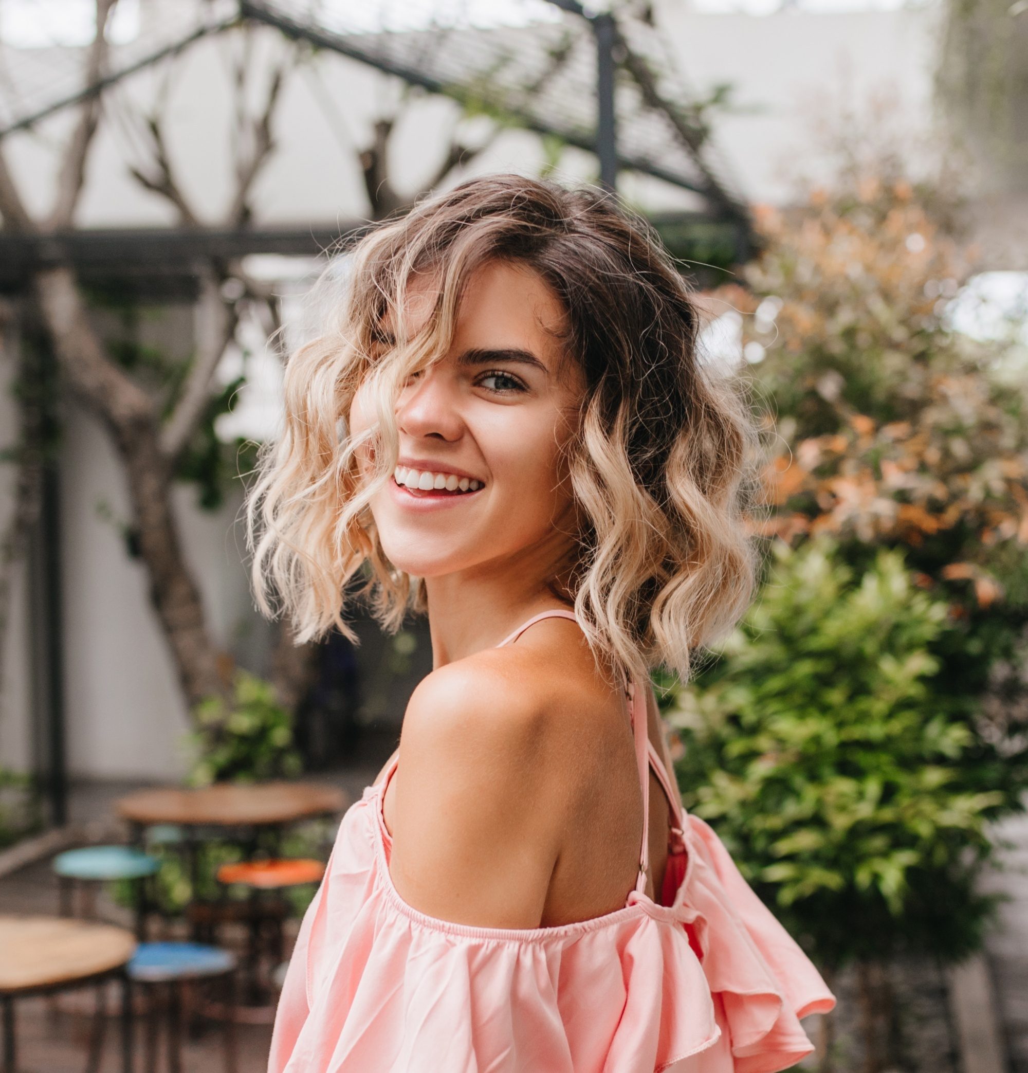 Layered curly hair: Woman with short ombre curly hair smiling
