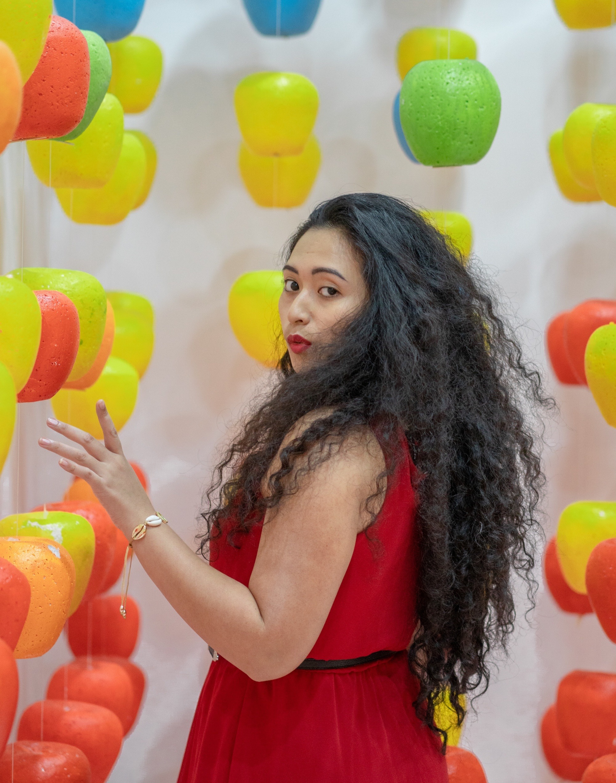Layered curly hair: Asian woman with long black curly hair wearing a red dress