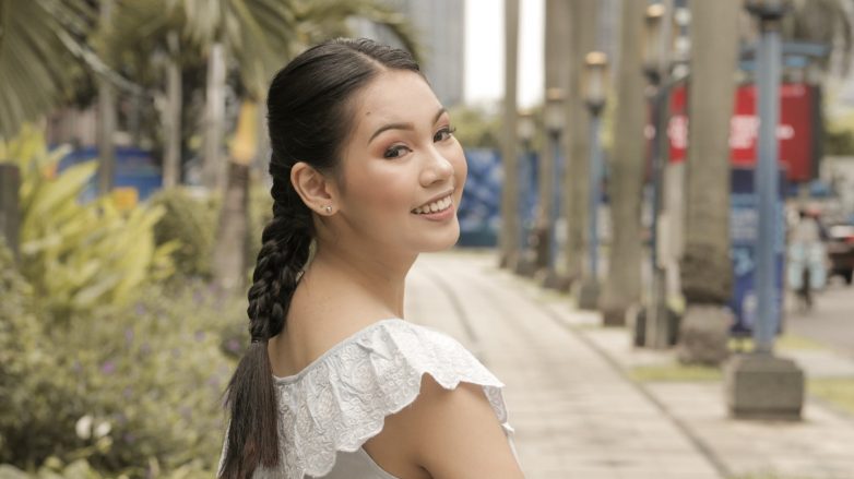 Asian woman with hair in triple braid smiling