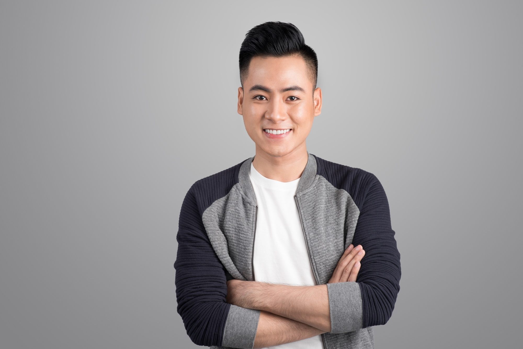 Asian man with a pompadour hairstyle smiling