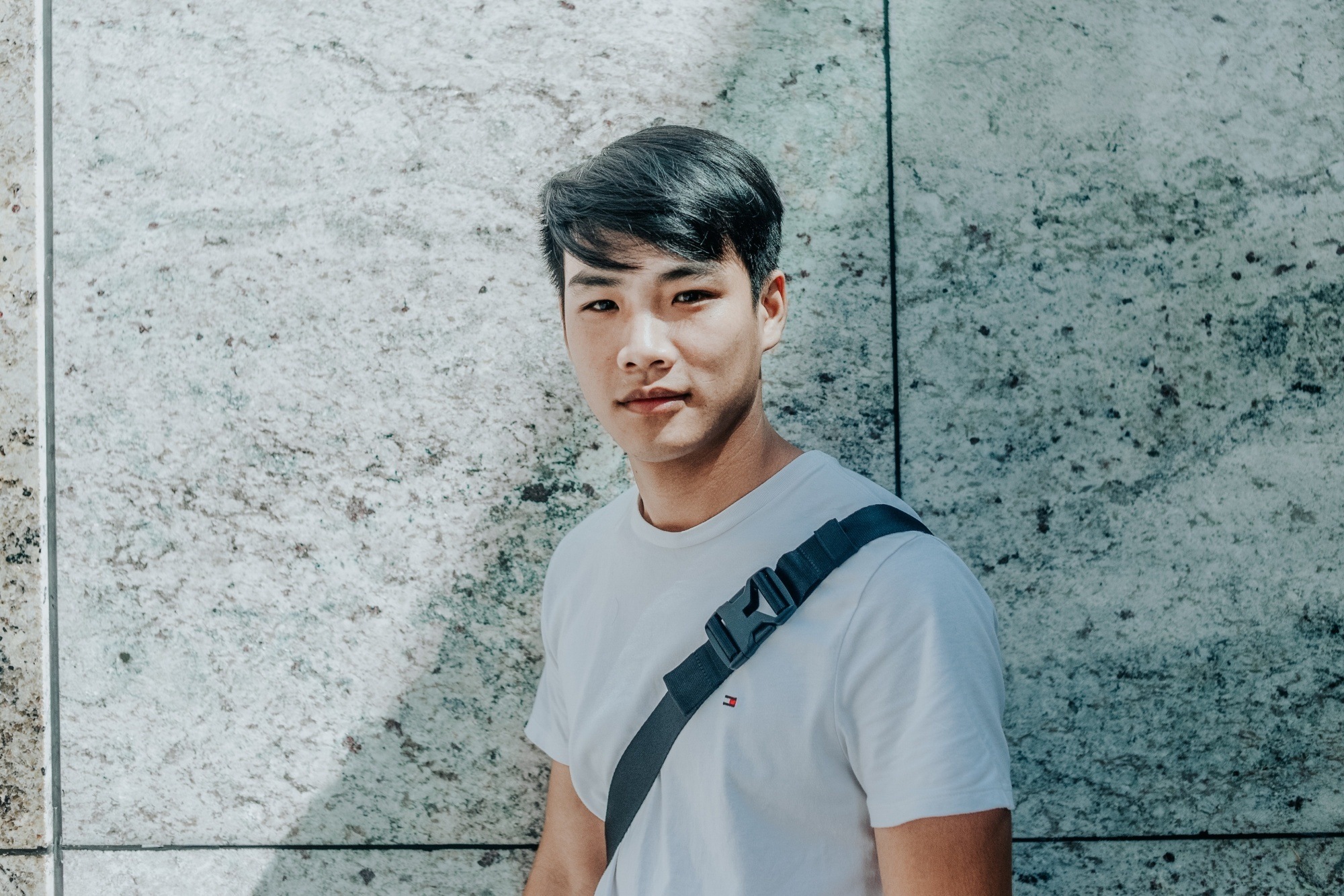 Asian man with a short side part haircut wearing a white shirt