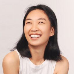 Asian woman smiling and posing for a hair care concept