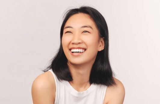 Asian woman smiling and posing for a hair care concept