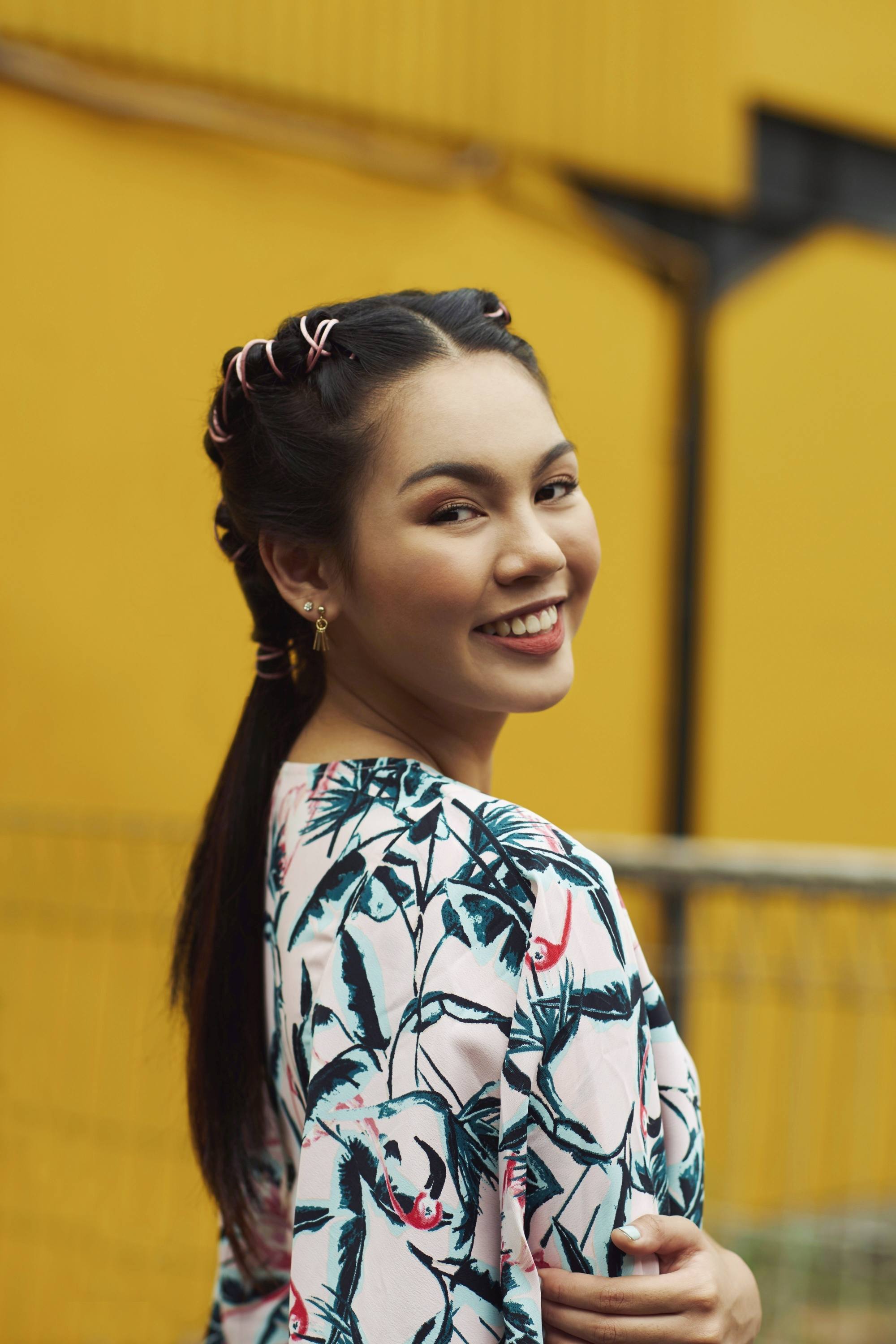Femme asiatique aux cheveux longs en tresses de tuyaux portant une robe imprimée